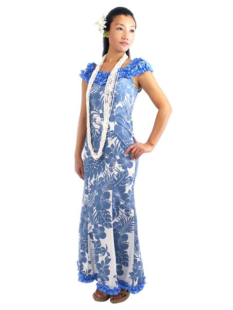 A woman wearing a blue and white floral long Muumuu dress with ruffle detailing and elastic shoulder sleeves.