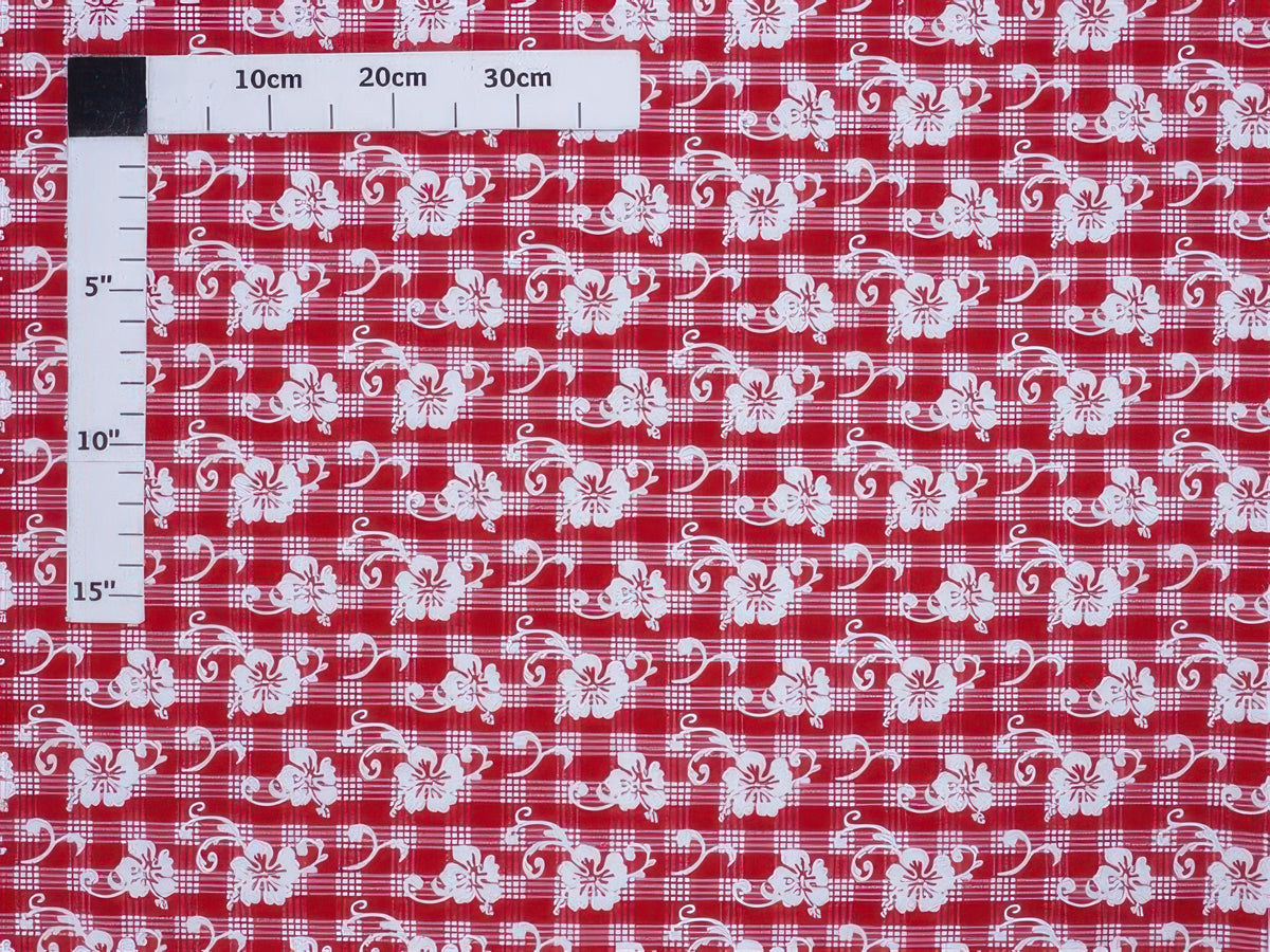 Red fabric with white floral patterns and a ruler for scale