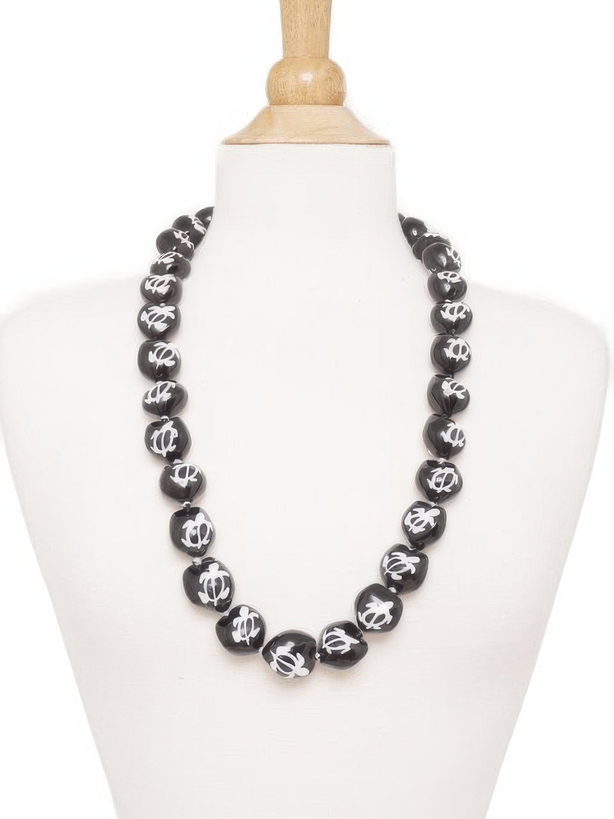 Black beaded necklace on a mannequin bust against a white background